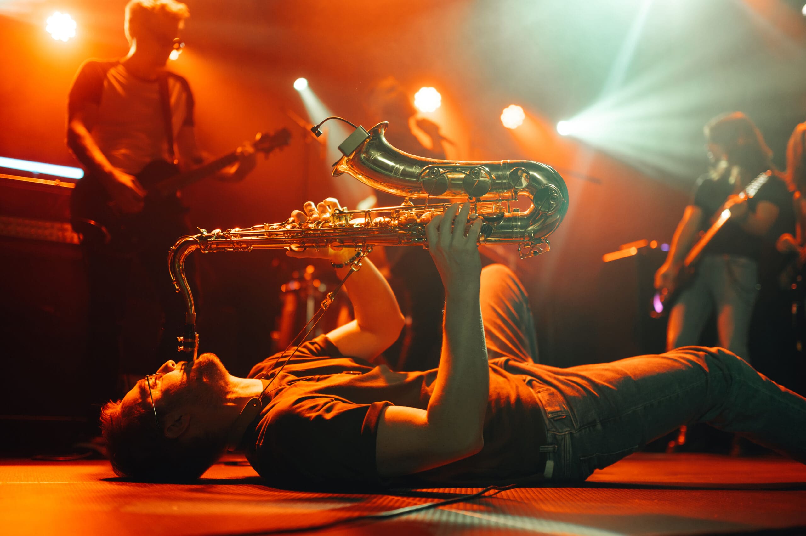 Saxophone player performing on stage with a band
